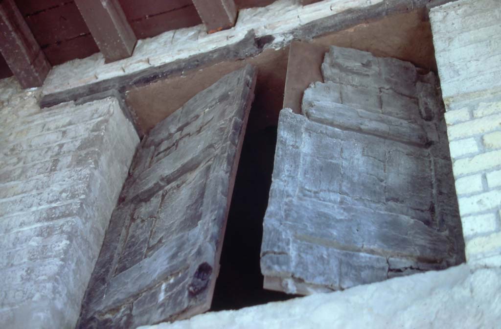 Decumanus Maximus, Herculaneum. 7th August 1976. Detail of window above doorway numbered 4.
Photo courtesy of Rick Bauer, from Dr George Fay’s slides collection.
